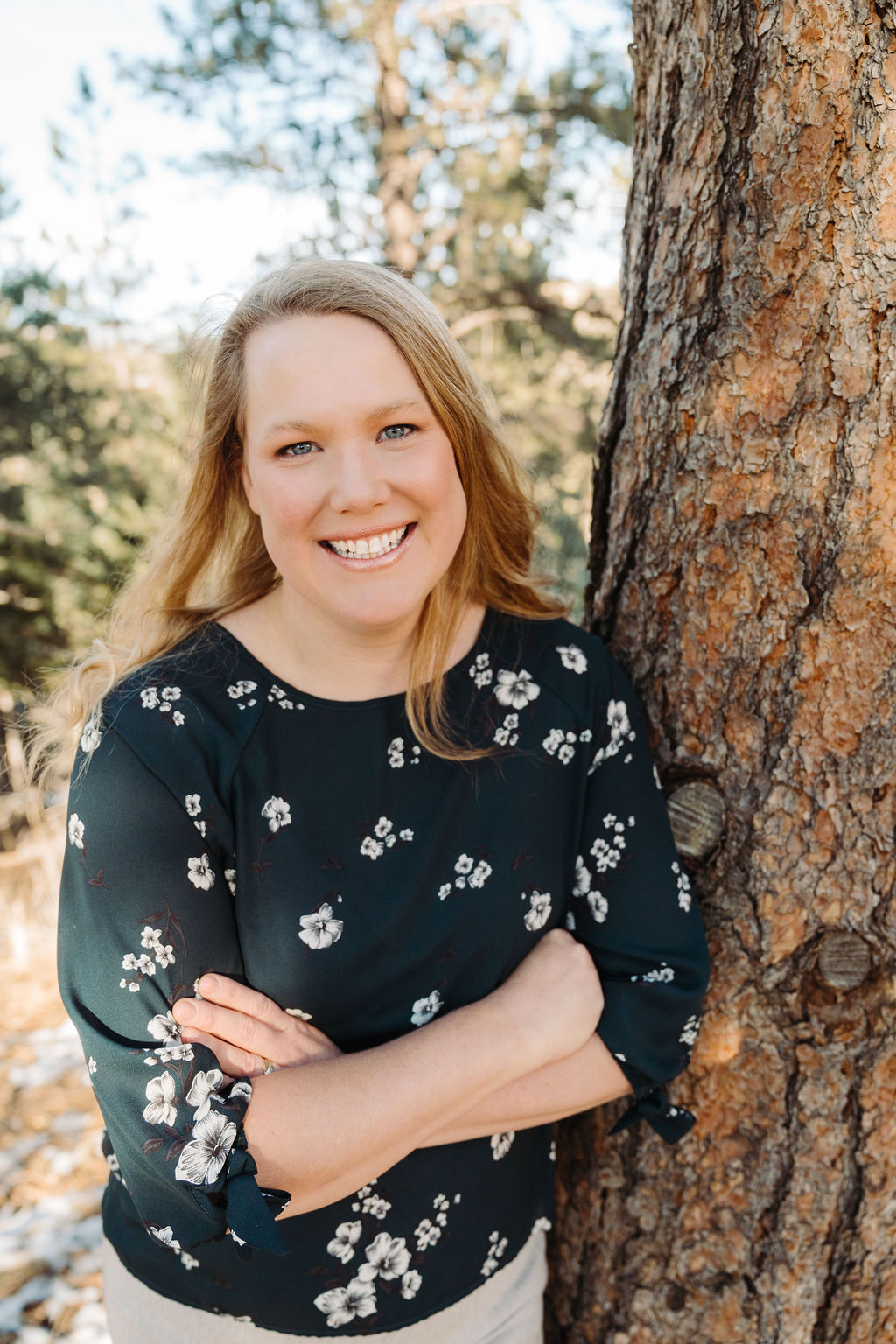 Photo of Heidi Albete standing outdoors beside a tree, smiling confidently in soft natural light.