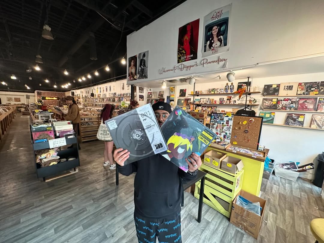 Customer holding two vinyl records at Nivessa Hollywood