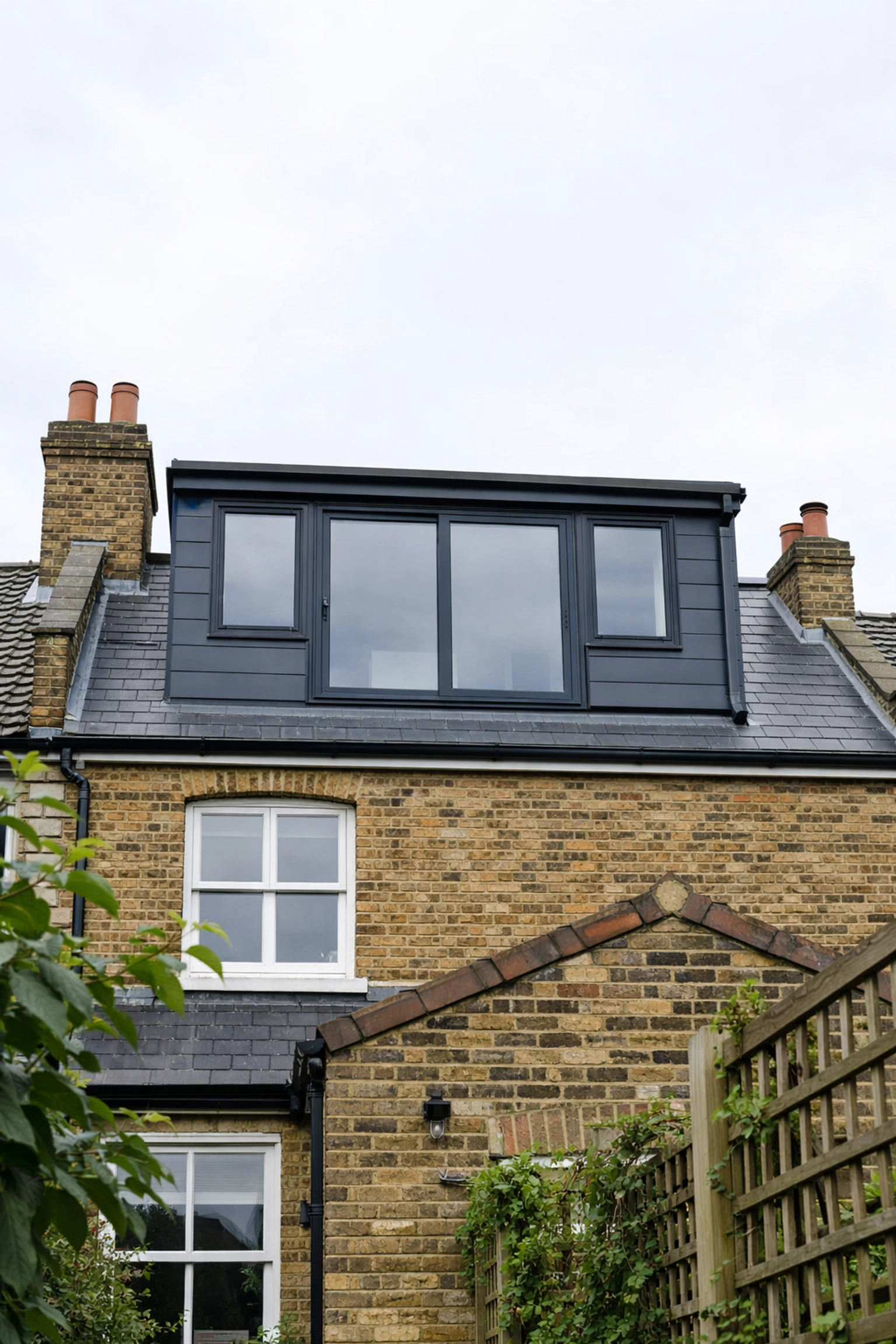 Modern rear dormer loft conversion featuring anthracite windows on a traditional London brick terraced house.