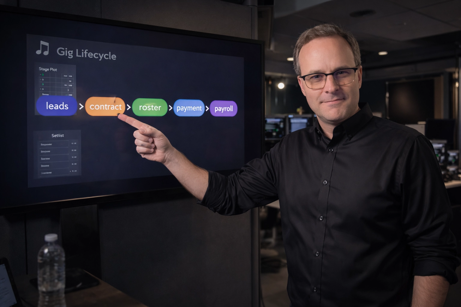 A man in a black shirt and glasses presenting