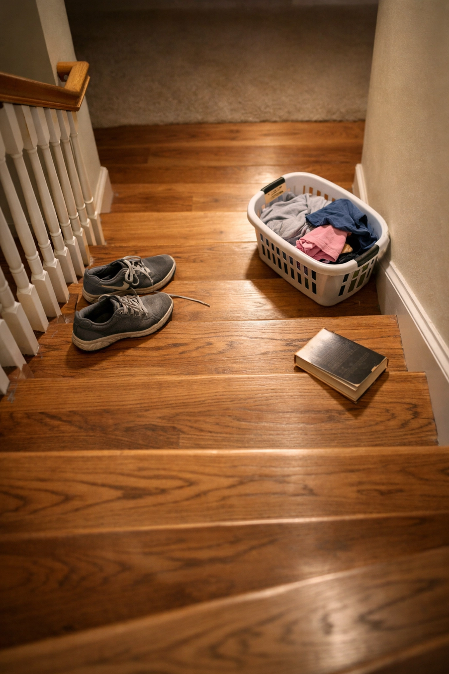 Cluttered stairs with shoes and a laundry basket creating dangerous tripping hazards for seniors.