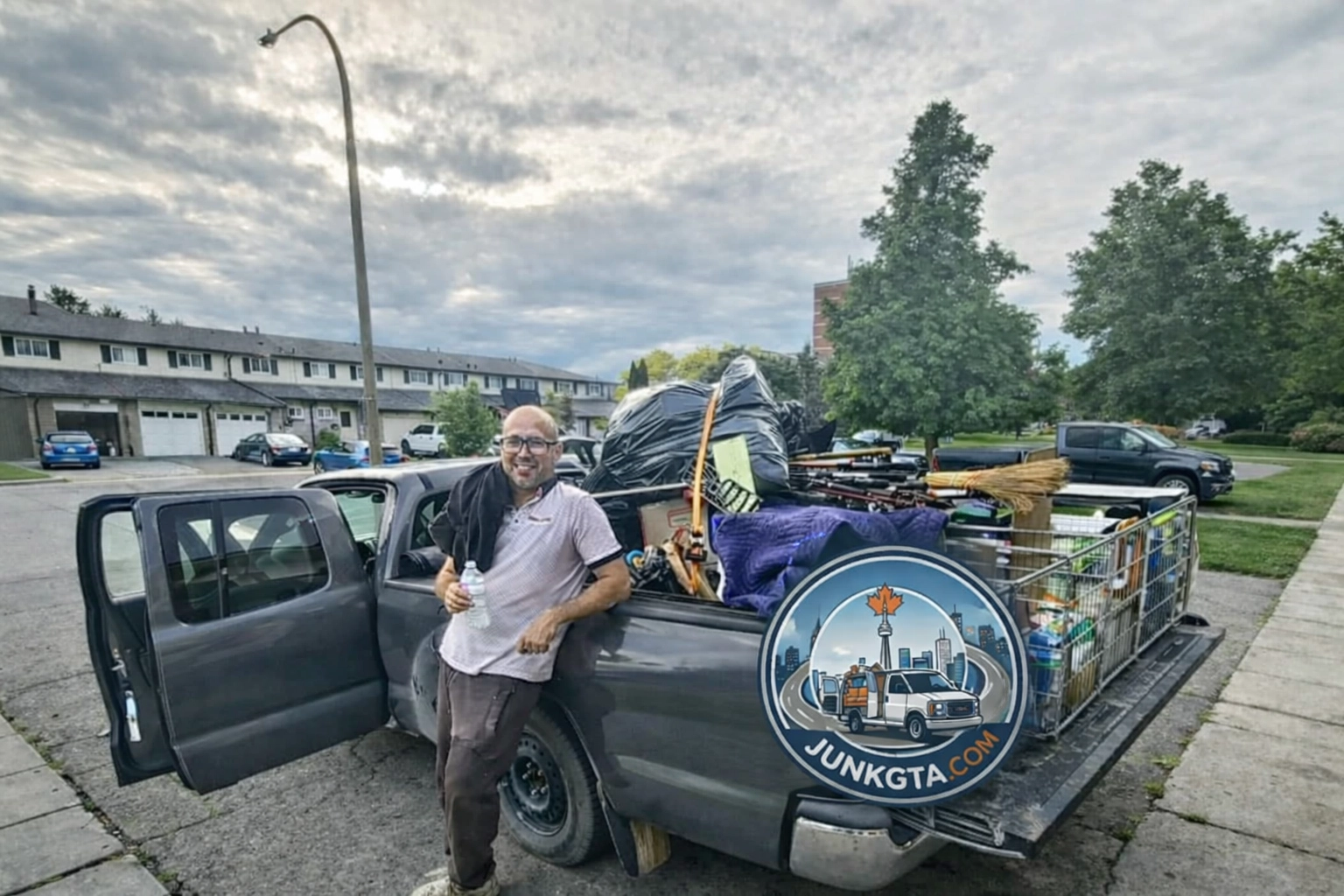 Commercial Junk Removal GTA: Scale Your Business Without the Clutter A Junk GTA crew member stands beside a pickup truck loaded with various junk items