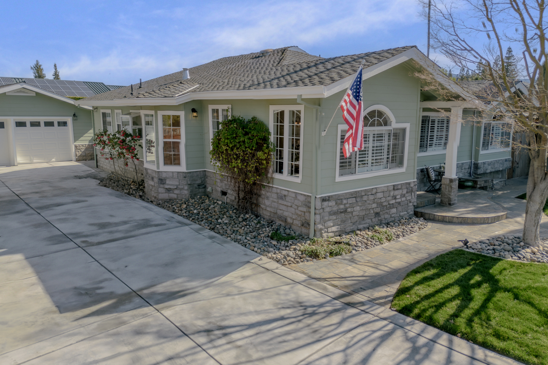 Single-story South Bay Home Fresh sage-green exterior with charming flower bushes and polished curb appeal—exactly the kind of first impression that makes buyers feel “this one is the one.”