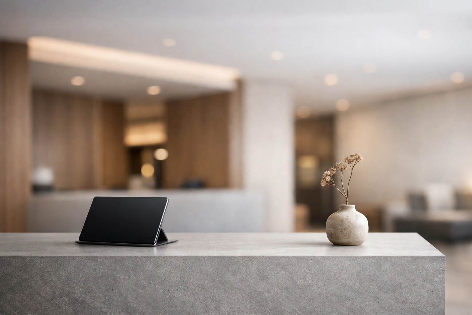 Minimalist hotel reception desk with integrated tablet for simple booking engine management.