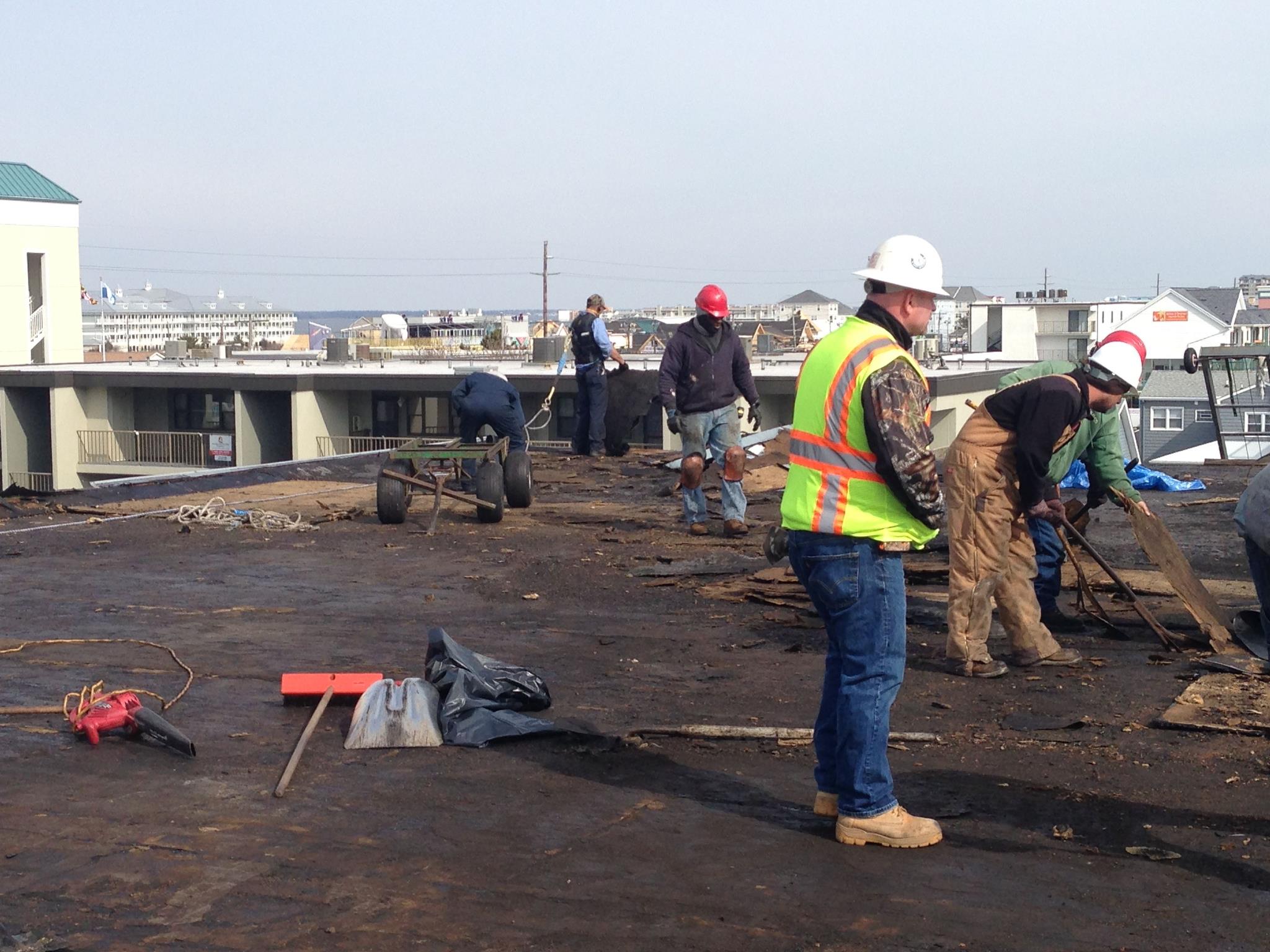 Peninsula Roofing Company crew working on commercial flat roof tear-off