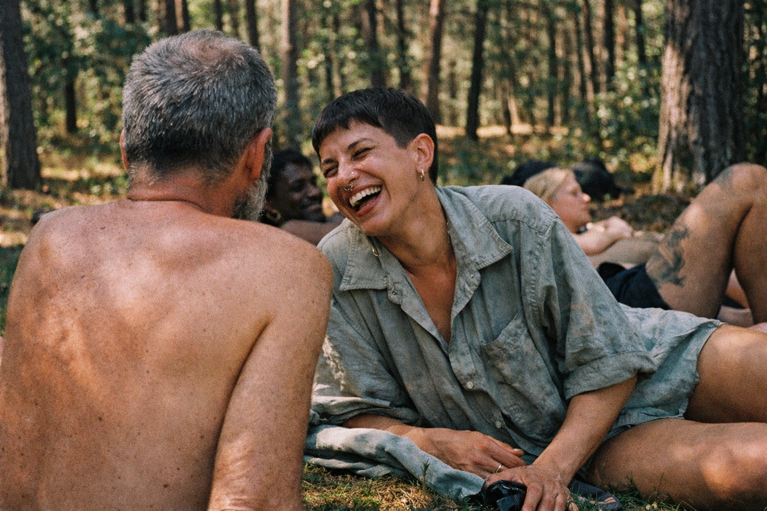 Friends relaxing in Grunewald forest near Teufelssee, embracing Berlin's FKK culture and nude sunbathing.