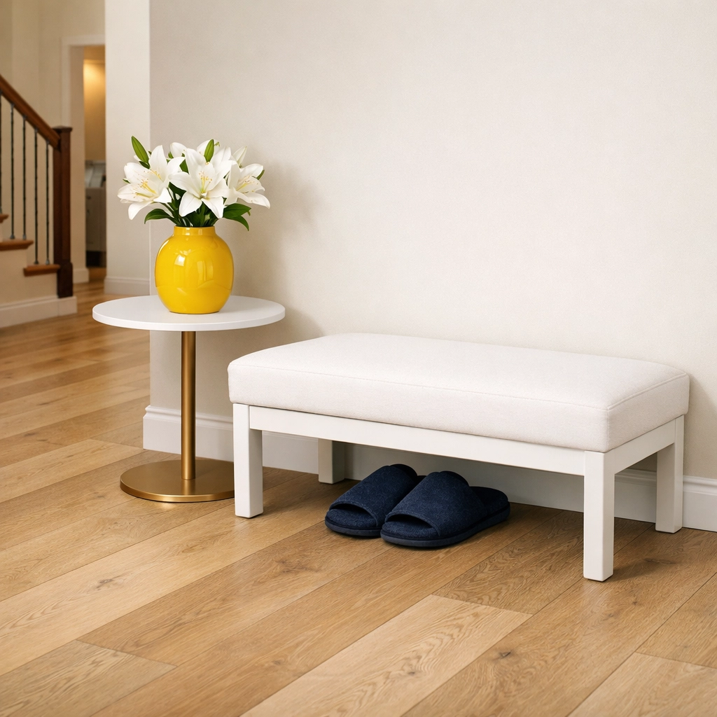 Pristine wide-plank hardwood floors in a protected Lunenburg entryway with slippers and a bench.