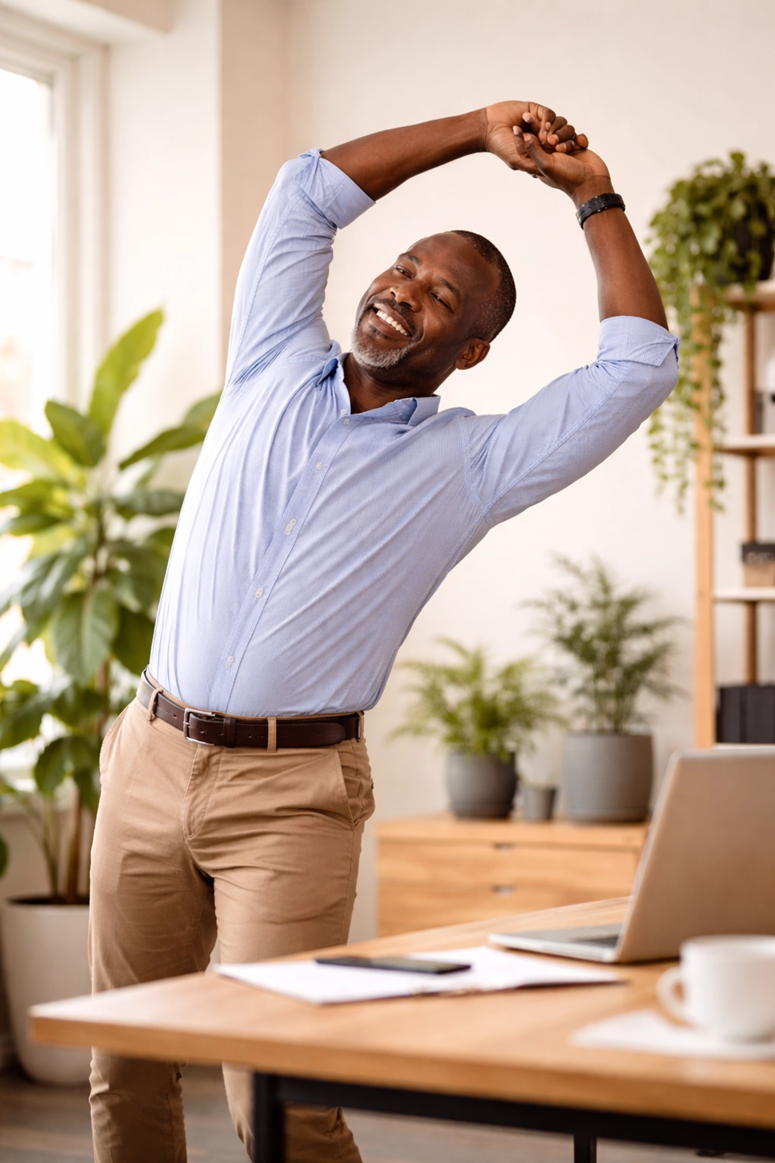 Man doing gentle stretches at his desk to boost afternoon energy and improve focus
