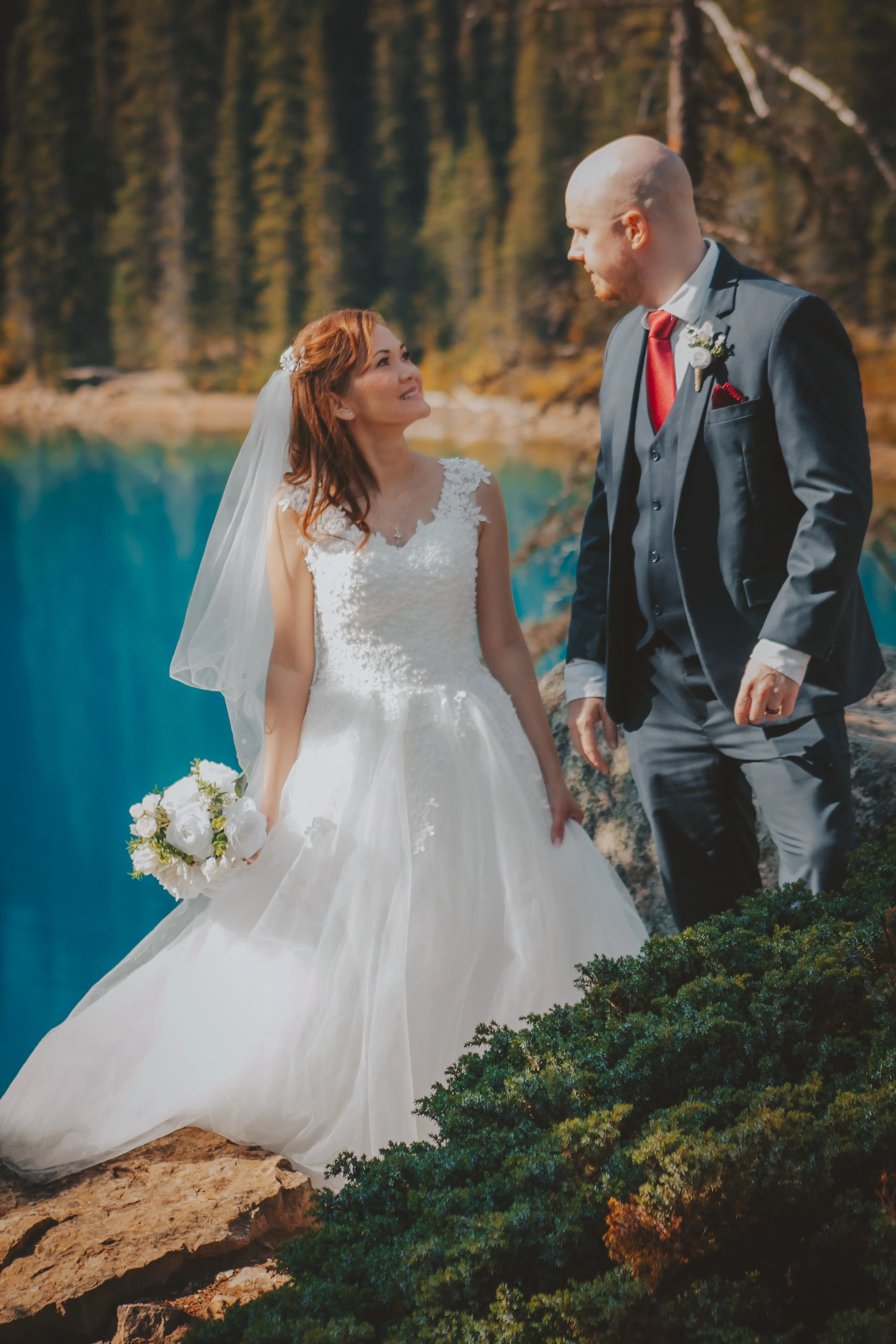 bride-groom-rocky-shore-turquoise-lake-banff