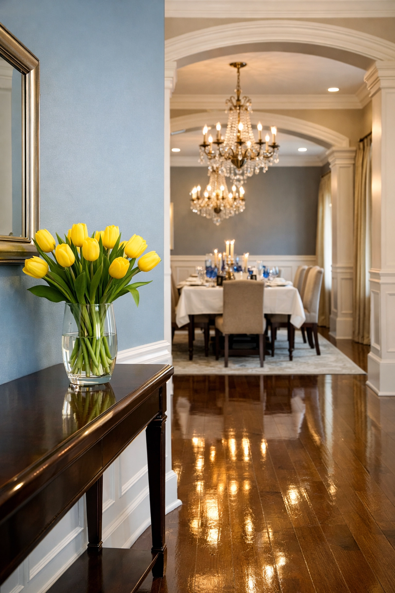 Spotless entryway and dining room with buffed hardwood floors maintained by expert weekly house cleaning.
