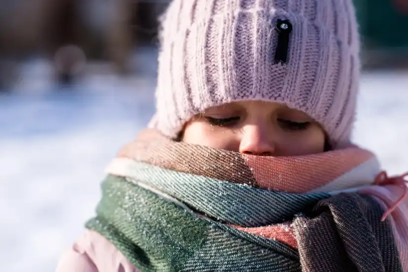Kid bundled up in a multicolored scarf — layering up and staying cozy during the NYC blizzard