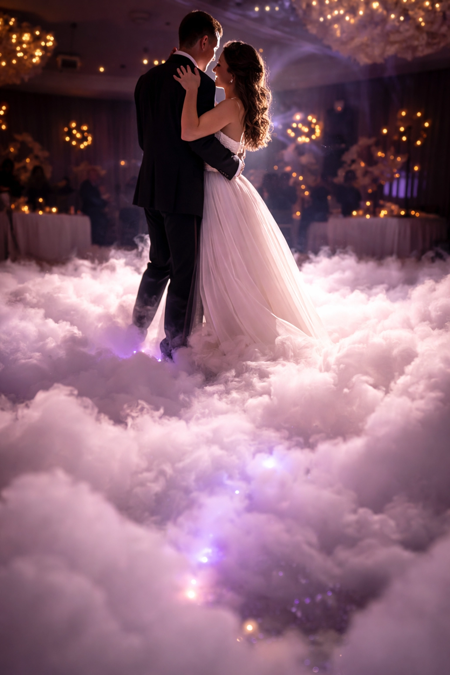 Bride and groom share their first dance on a cloud effect with romantic uplighting at a wedding reception