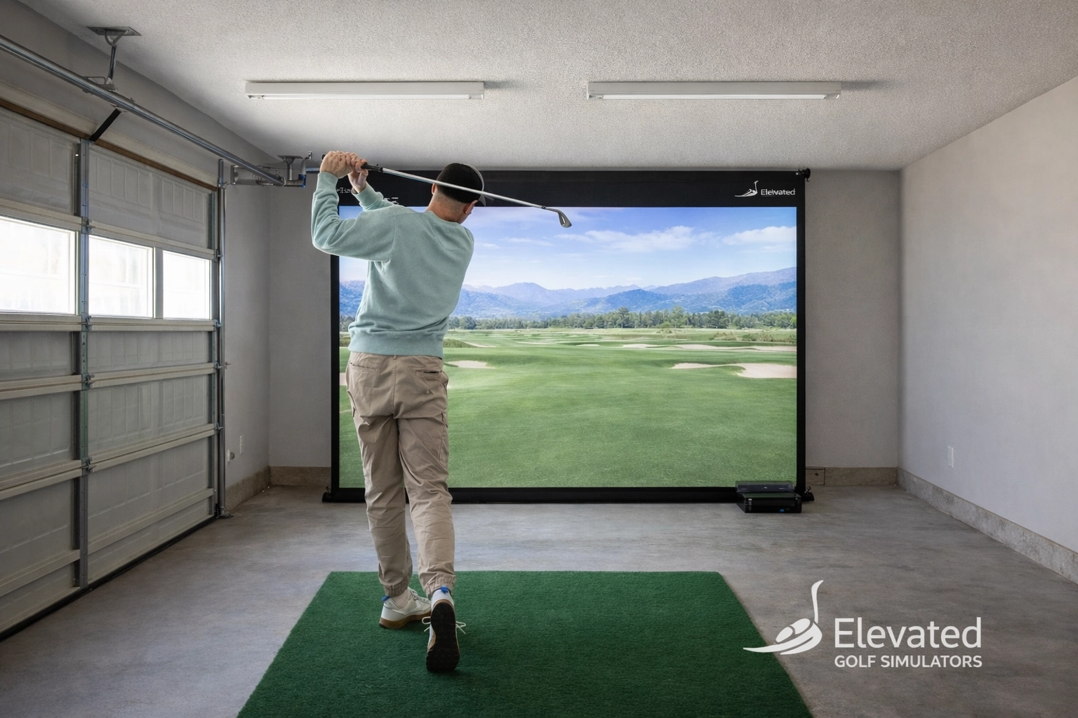 A golfer practices a full swing indoors, highlighting the necessary ceiling clearance for a safe and effective setup.