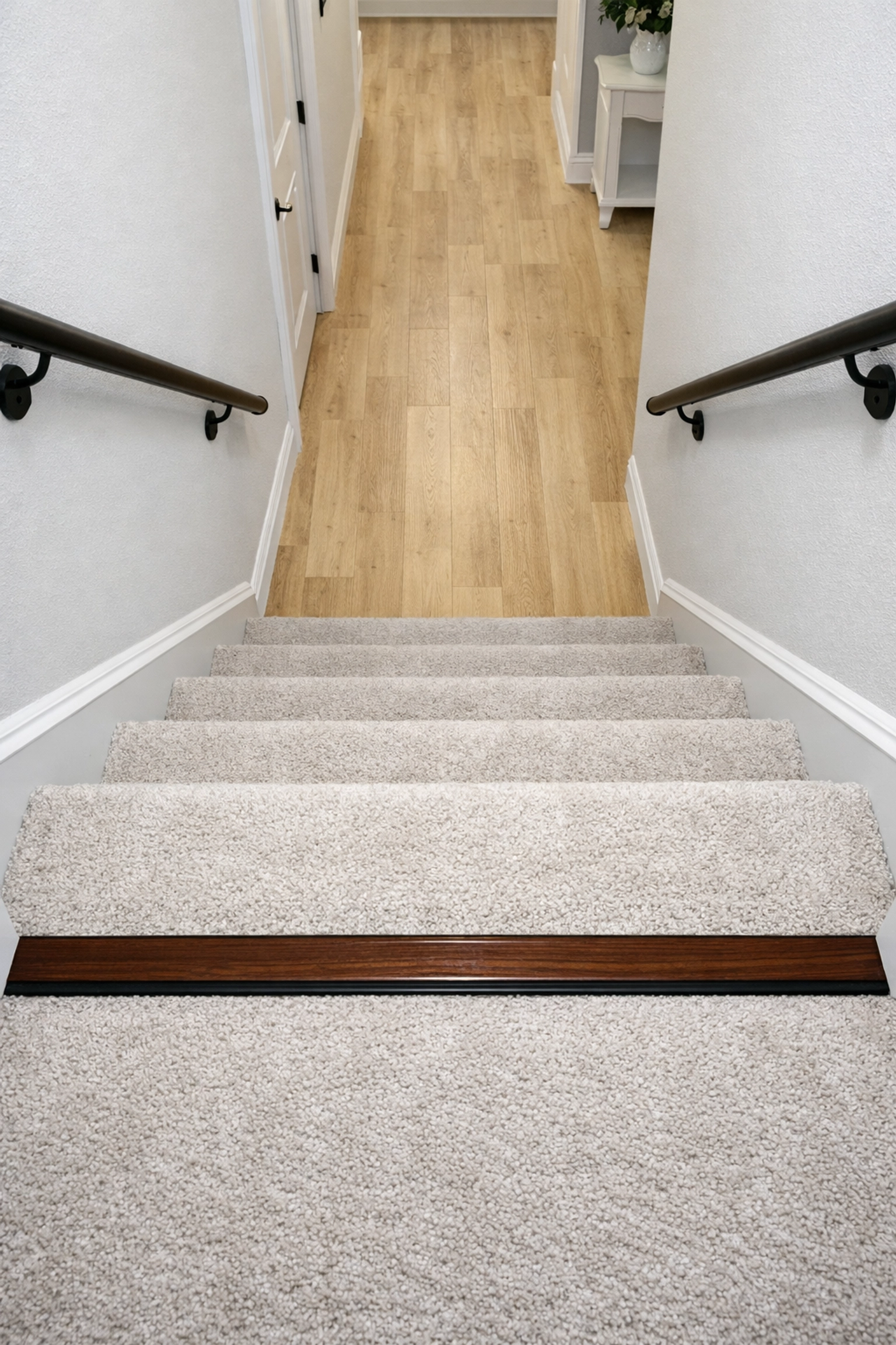 View looking down stairs with a contrasting edge on the bottom step for visibility