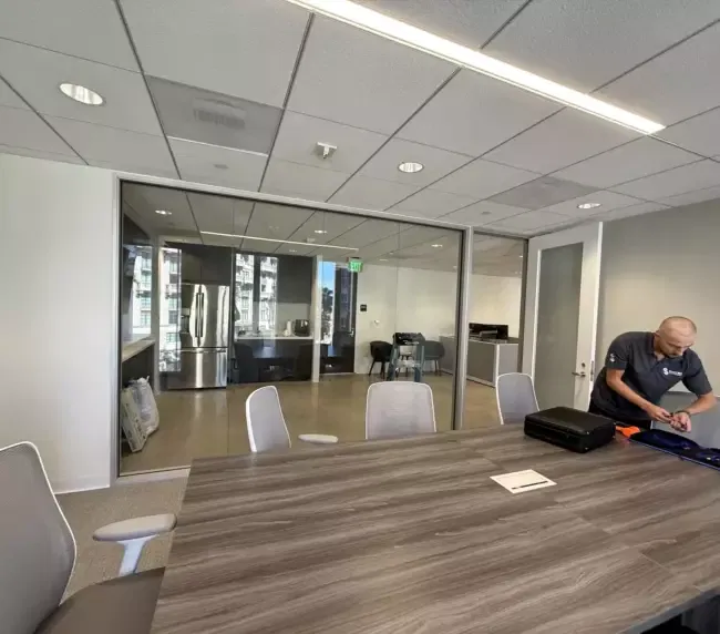 A modern commercial office lobby featuring switchable smart film on glass partitions, showcasing a clean and professional aesthetic