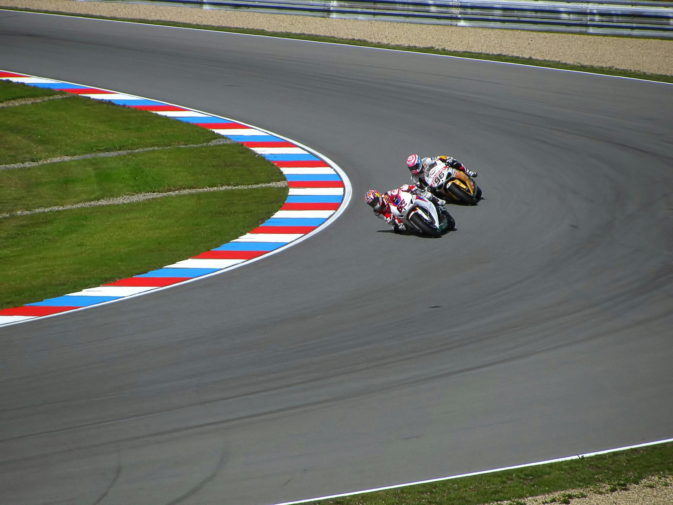 Two high-performance motorcycles on racetrack representing precision and agility