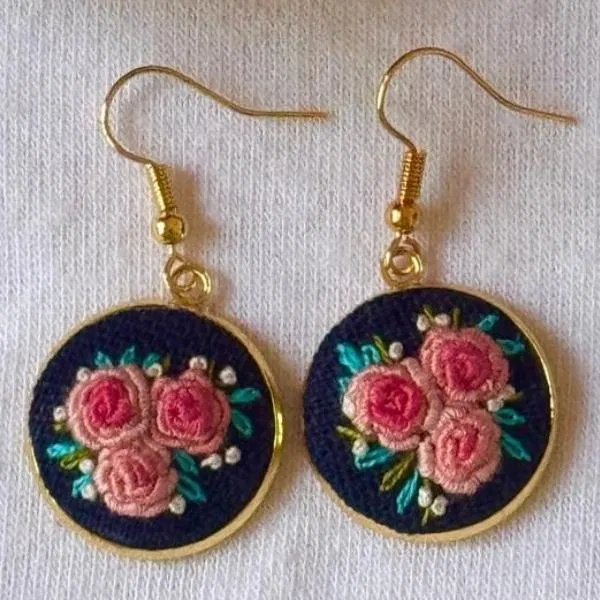 Round earrings with pink rose embroidery on navy blue linen