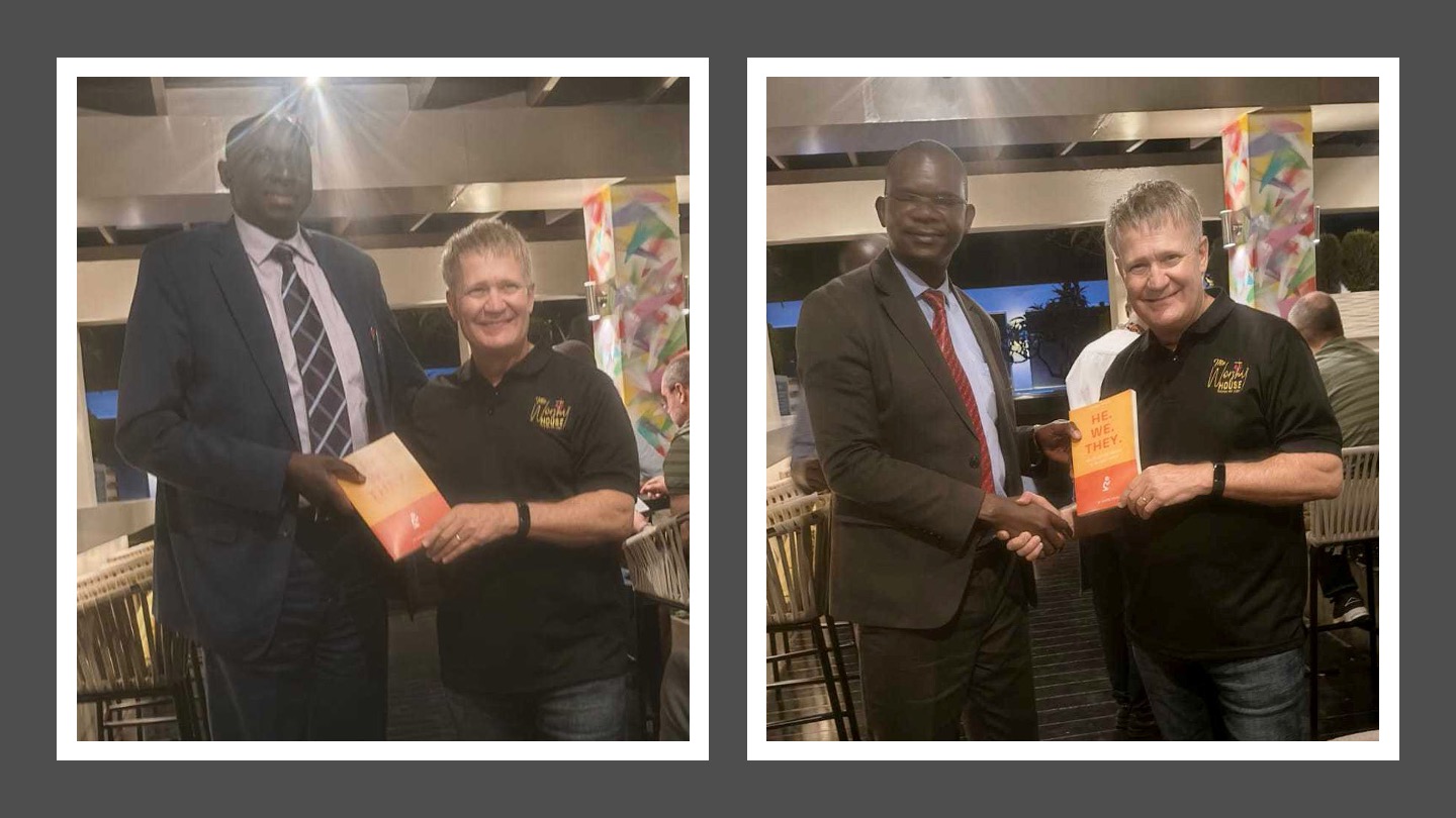 Dwayne pictured with two men in suits, holding He We They books; illustrates large-scale church resourcing and partnership