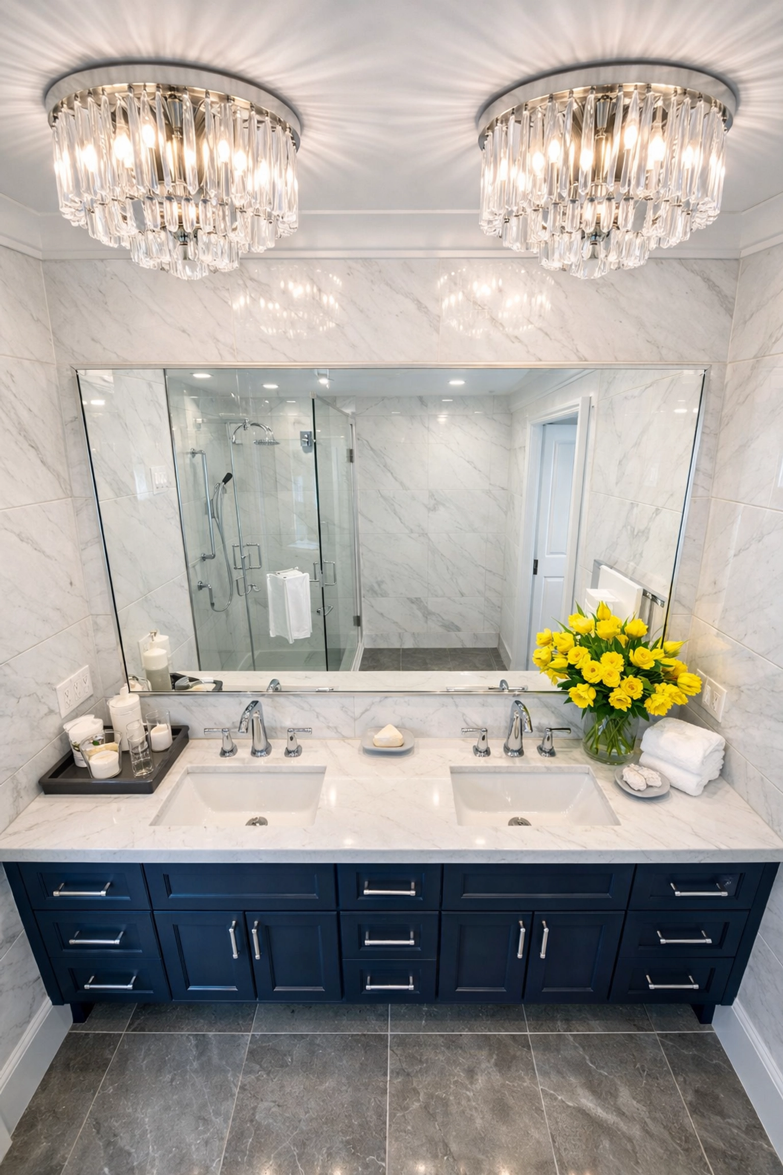 Sparkling marble bathroom with navy vanity following professional residential cleaning in Leominster MA.