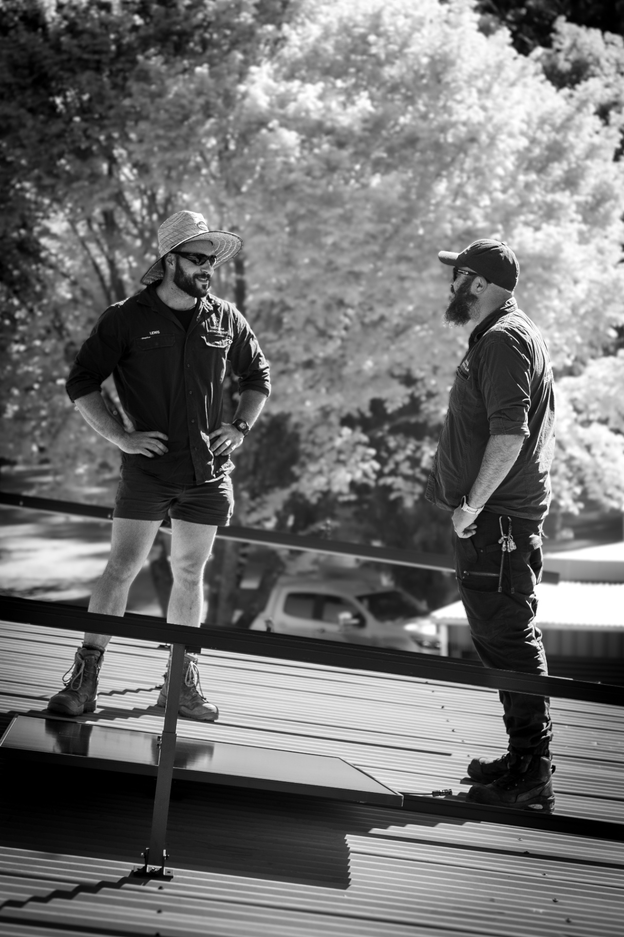 Two Trentham Electrical & Solar technicians installing solar panels on a roof in Central Victoria