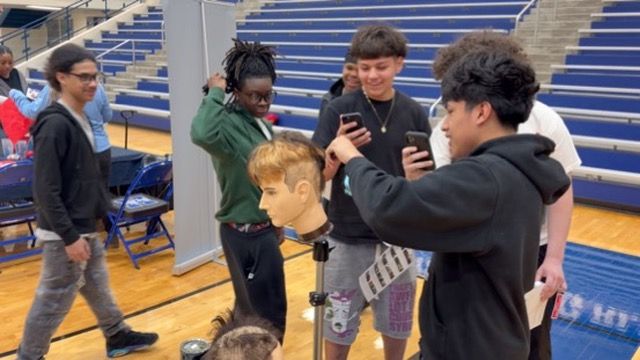 Hamilton HS Career Fair - Hands-on Demo 1 Student performing a hands-on haircutting demo on a mannequin at Hamilton High School career fair.