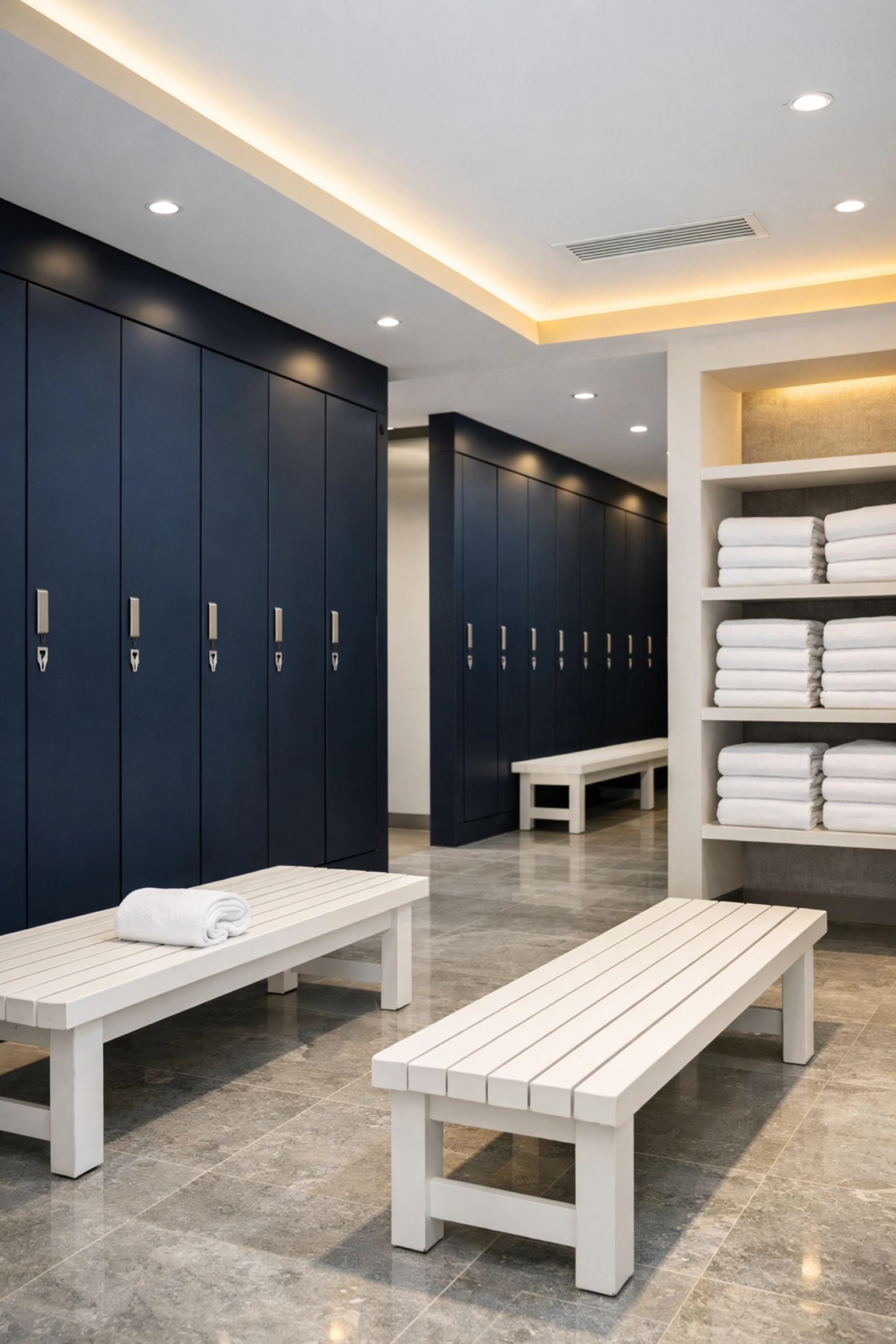 Spotless high-end gym locker room with navy lockers, fresh towels, and professional sanitization.