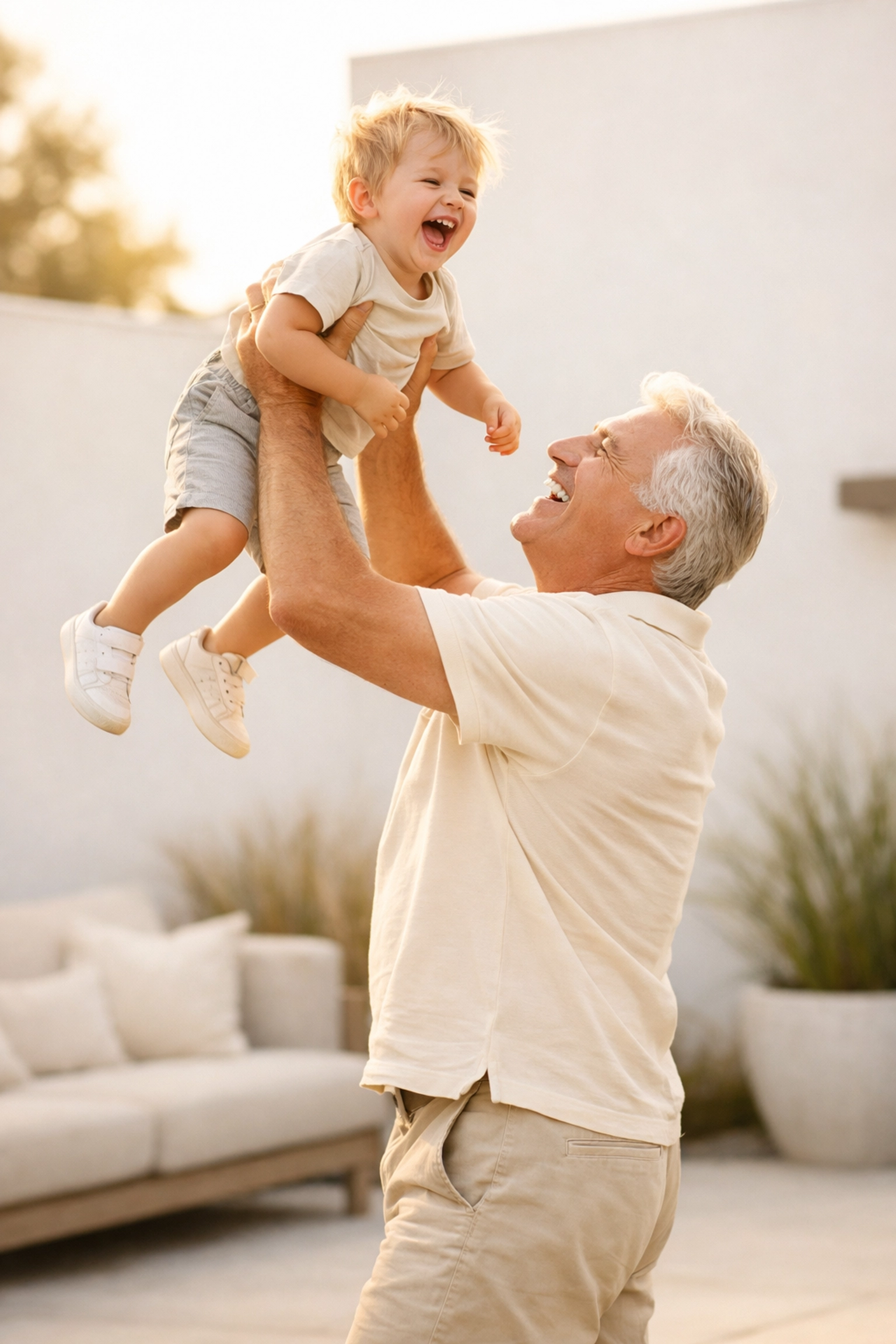 Active grandfather lifting grandchild after successful sciatica relief treatment.