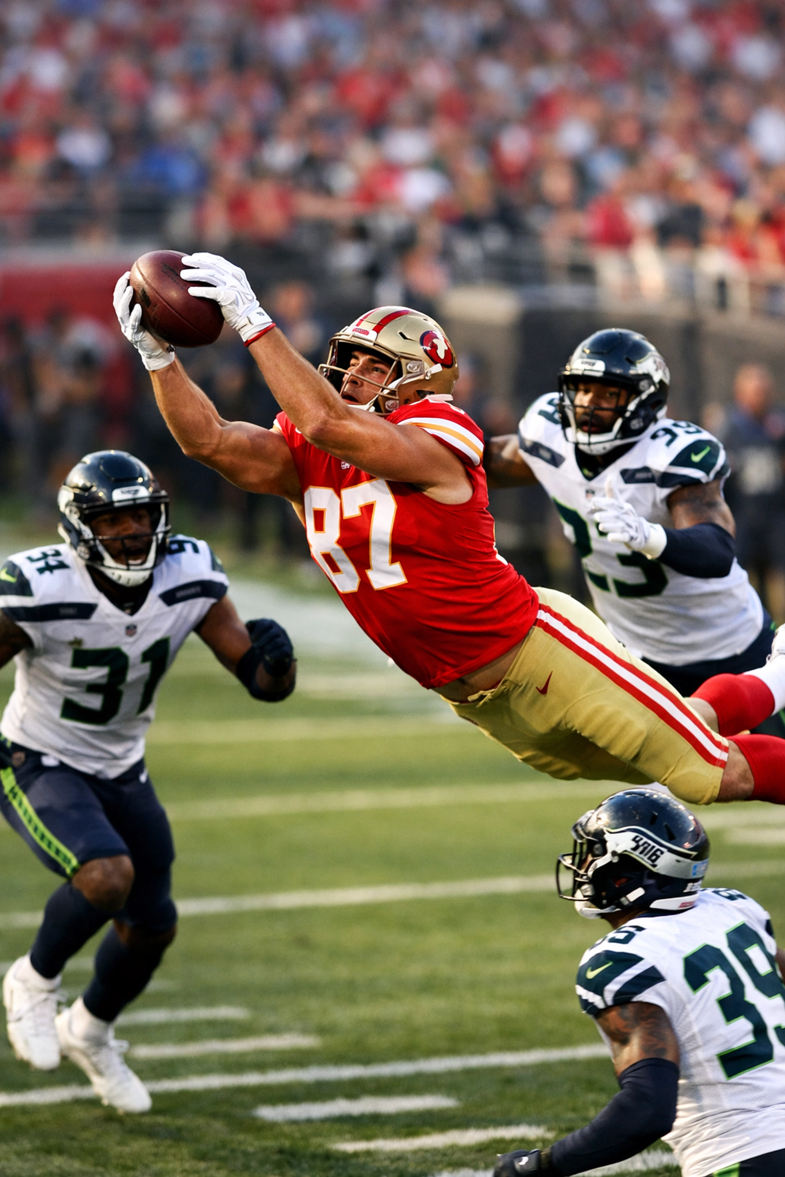 NFL tight end making athletic catch in traffic surrounded by defenders