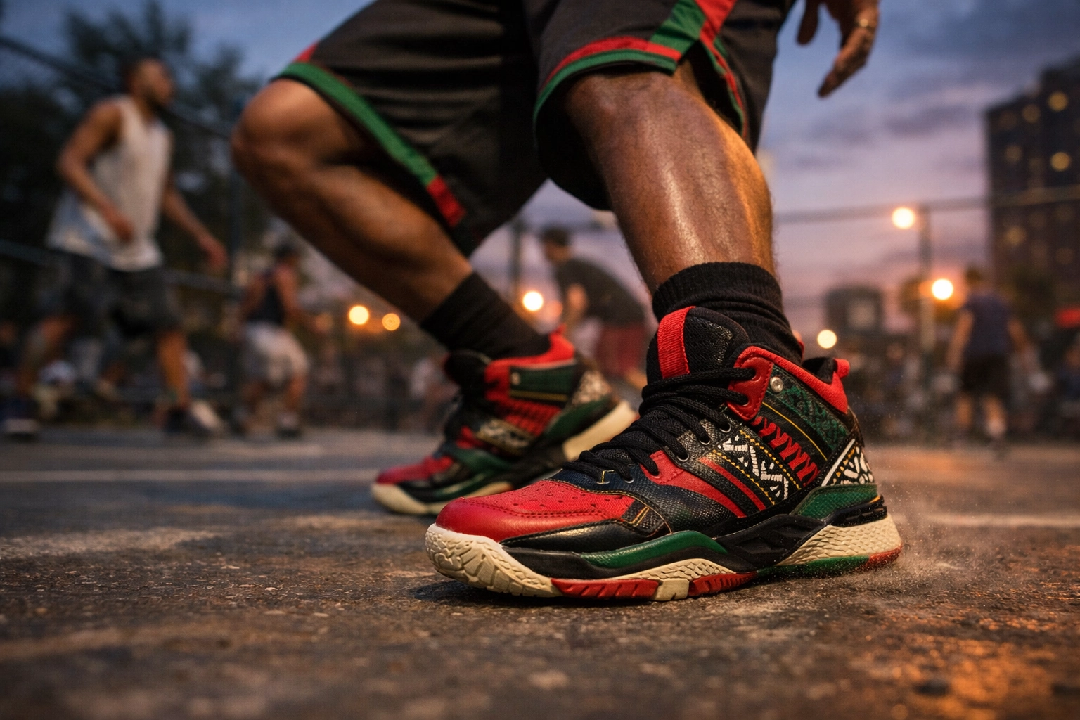 Person wearing red, black, and green culturally-inspired sneakers on an urban basketball court, displaying cultural pride and style without any mainstream logos