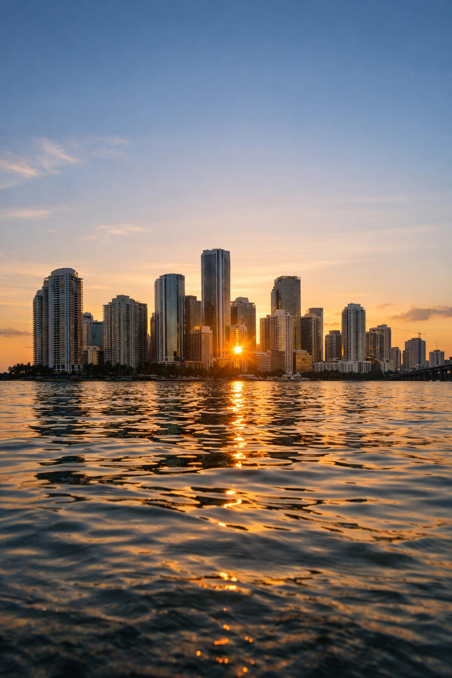 The Downtown Miami skyline at sunset from South Pointe Park, highlighting the city's magic and light.
