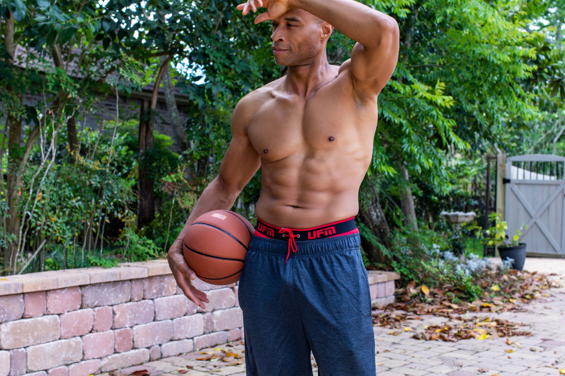 Athletic man outdoors holding basketball