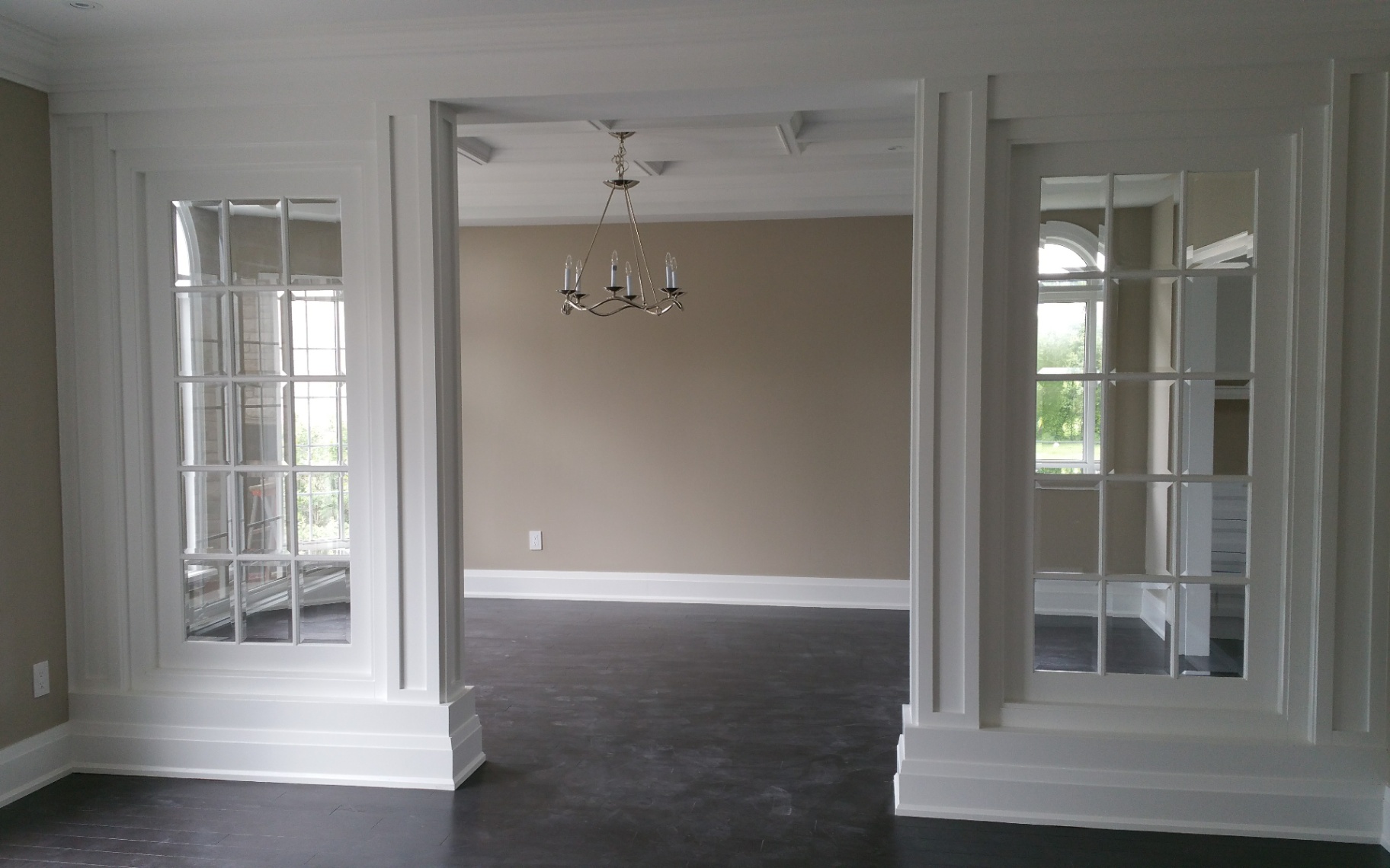 Custom entryway trim with dark hardwood floors showcasing crisp casing lines and premium workmanship