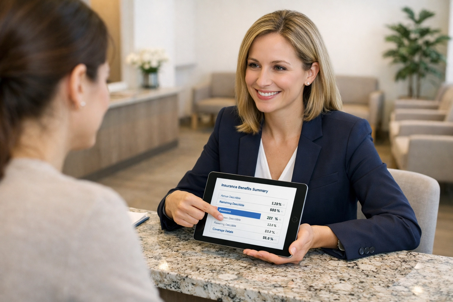 Stop Chasing Payers. Make Them Pay You. Clinic front desk coordinator explaining insurance benefits and deductible resets to a patient.