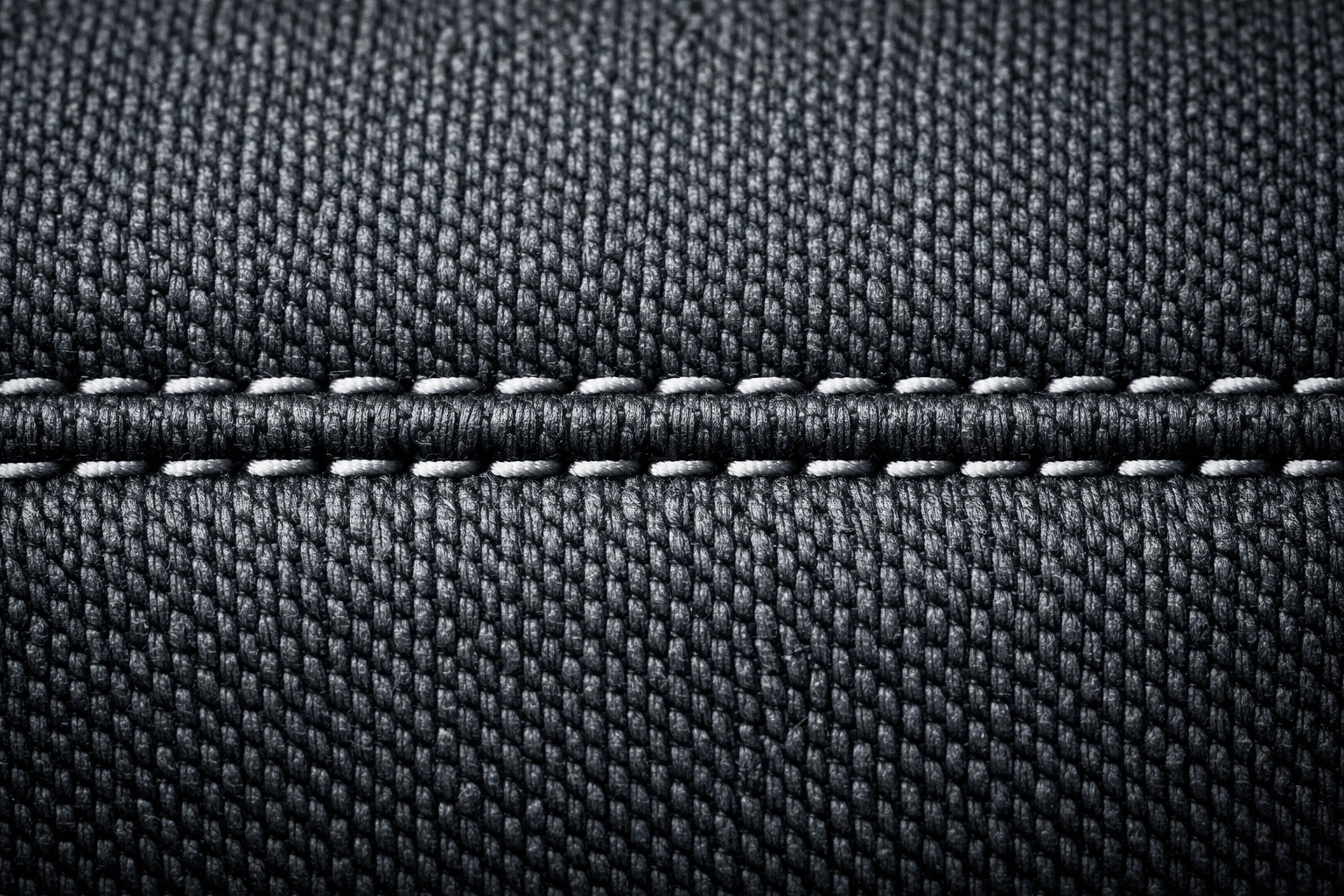 Detailed close-up of a professional, straight upholstery seam showing expert furniture craftsmanship.