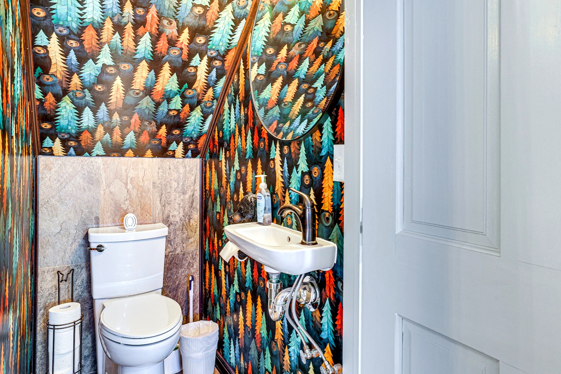 Powder room at Bearly Roughing It with whimsical bear and forest-themed wallpaper.