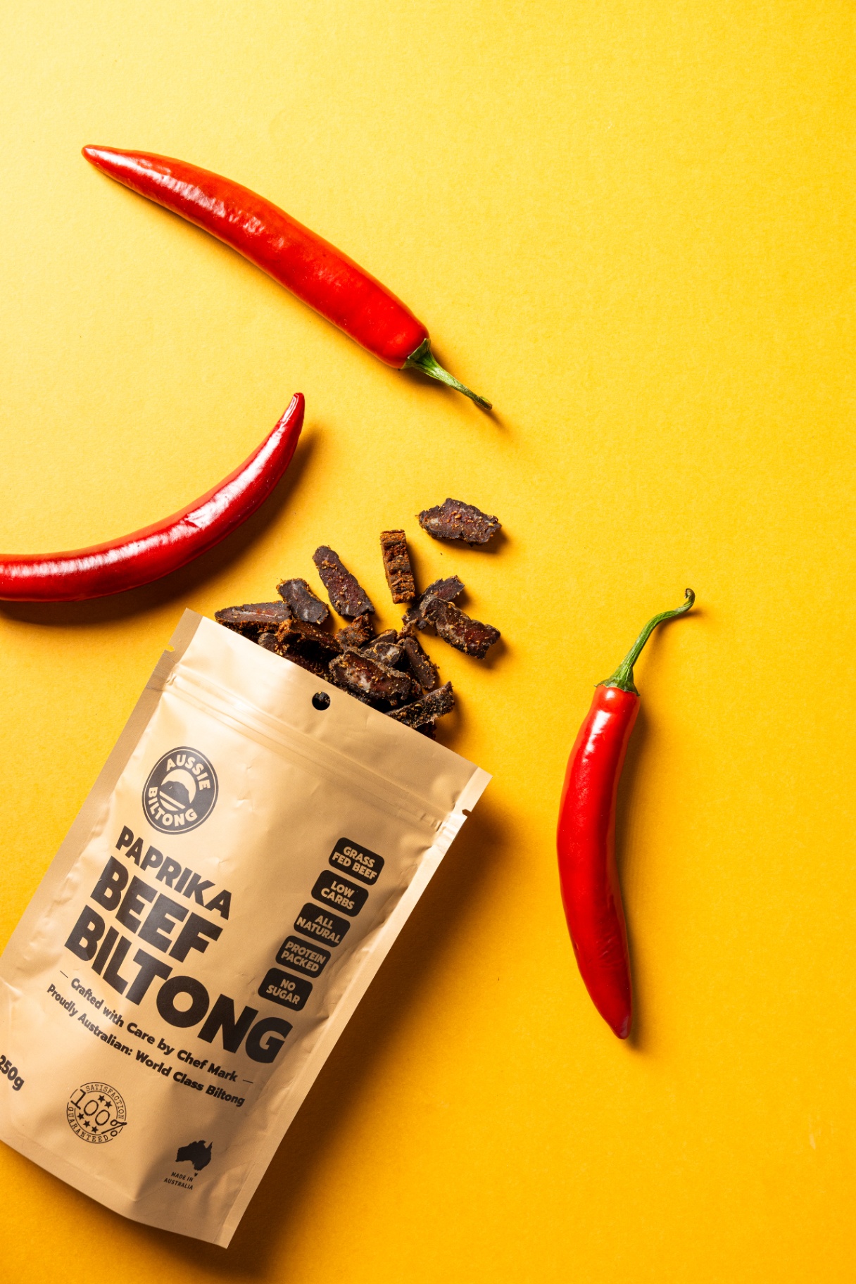 Open packet of Paprika beef biltong with fresh chillies, biltong snacks, high protein snacks, healthy meat snacks, biltong nutrition, air dried beef