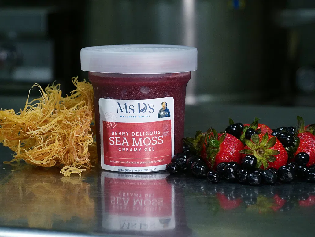 Nine 16oz glass jars of Ms. D’s Wellness Goods Sea Moss Gels arranged in a neat row, featuring vibrant flavors.