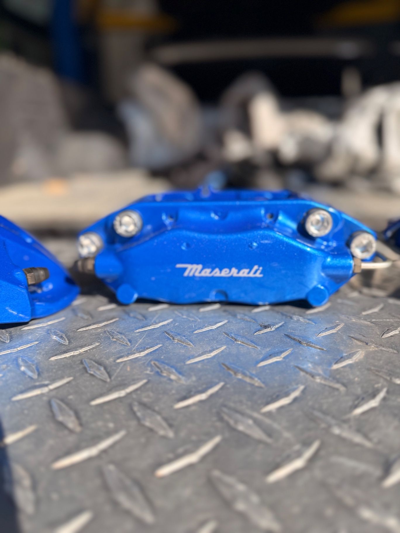 Main logo close-up: ultra-gloss blue with white Maserati decal