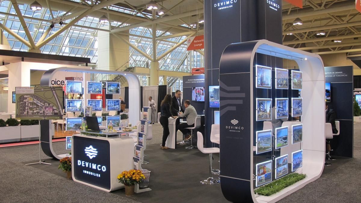 Modern trade show booth activation with interactive kiosks at a business exhibition