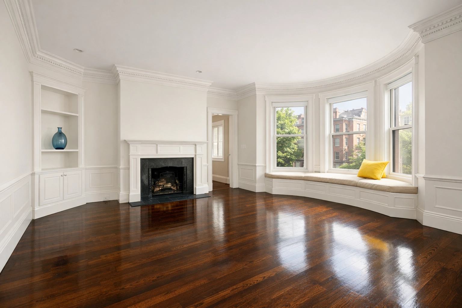 A spotless, empty Boston brownstone living room with polished hardwood floors after a professional apartment turnover.