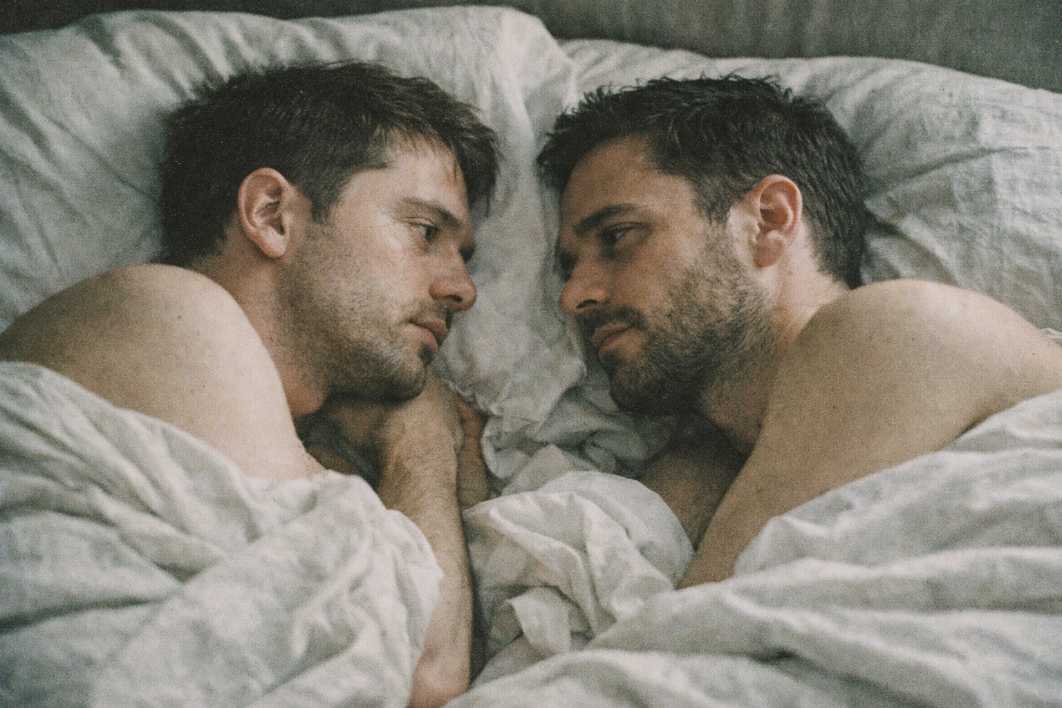 Gay couple in bed showing vulnerability and emotional complexity in MM romance
