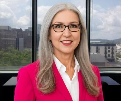 Professional businesswoman in a bright pink blazer standing confidently
