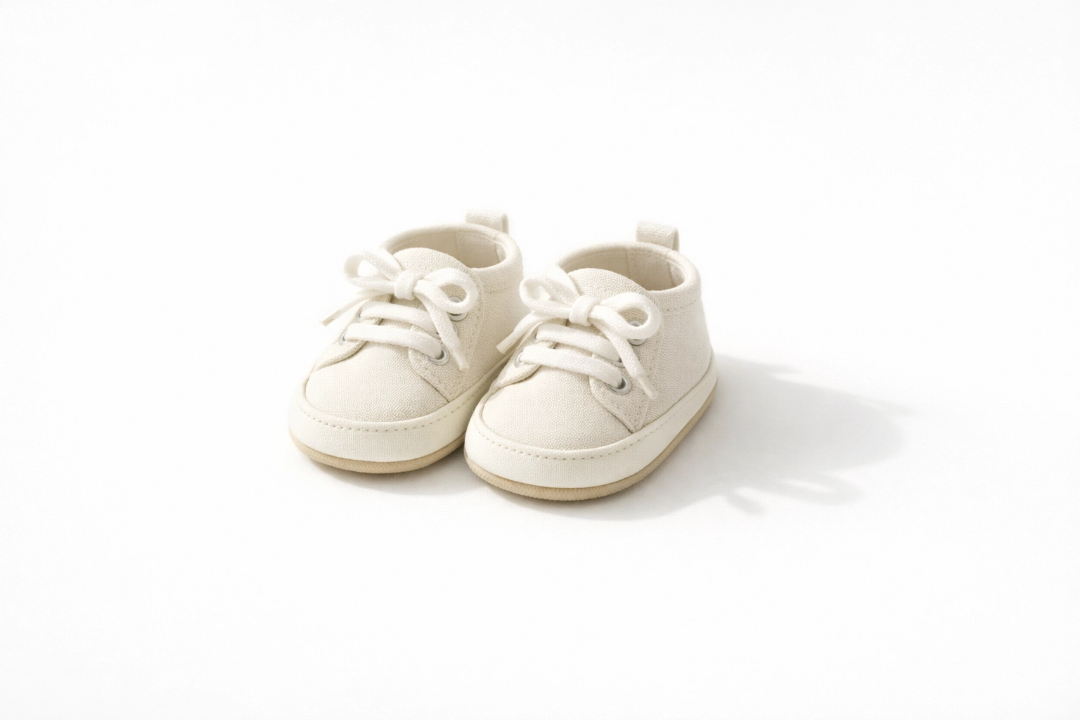 Minimalist tiny baby shoes on a clean white background