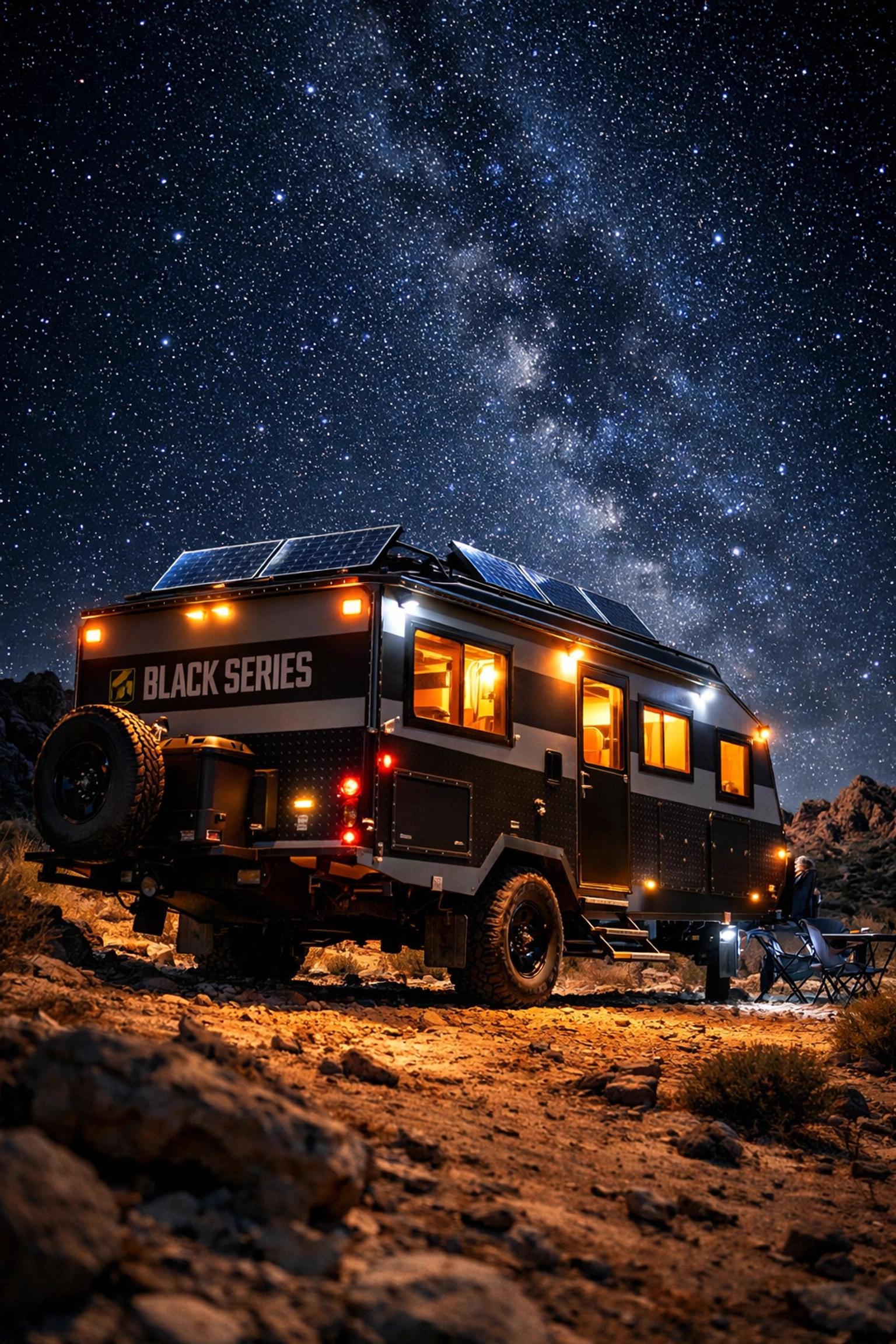 Off-road travel trailer with solar panels parked under starry sky in remote desert location
