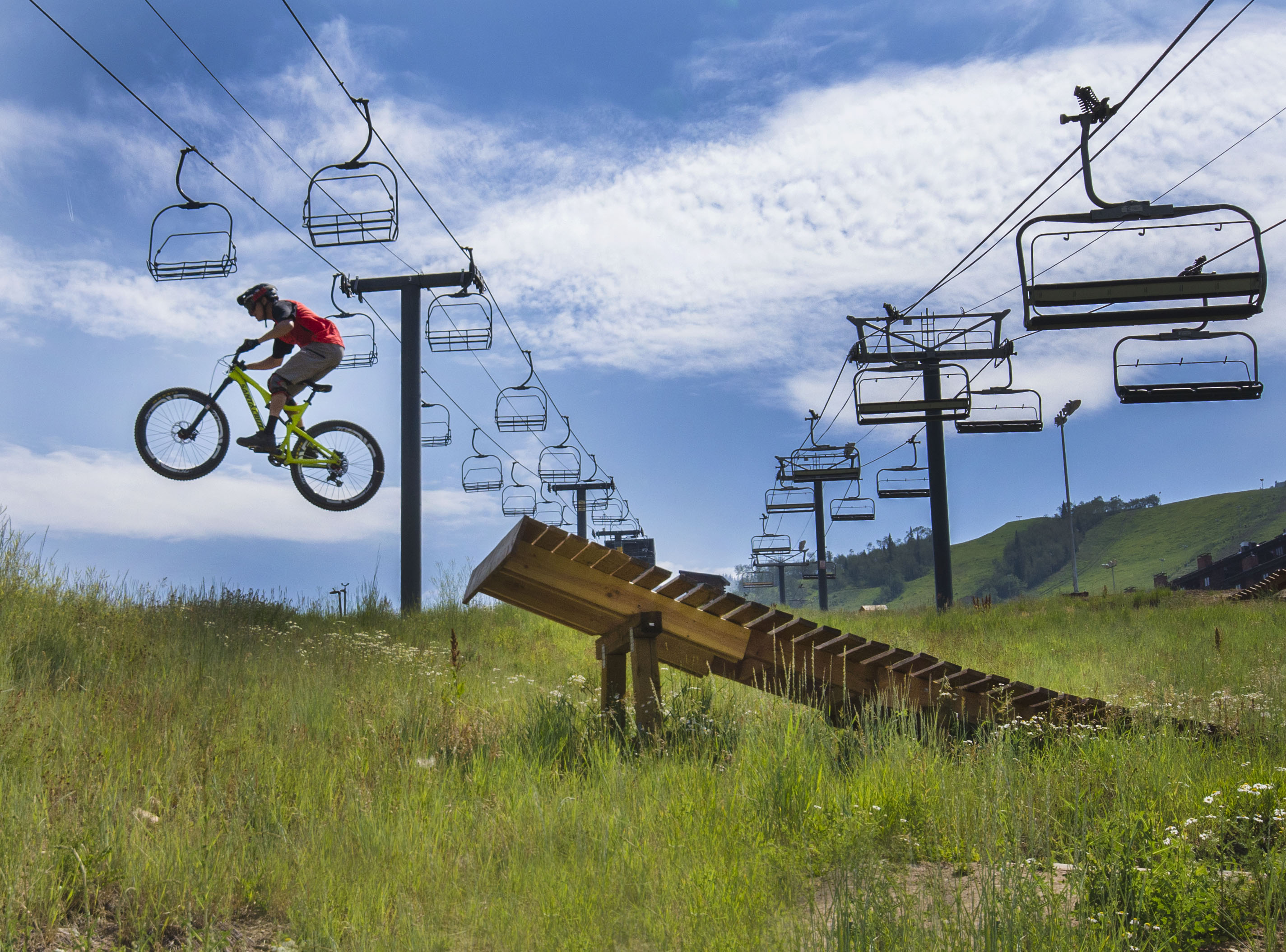 Mountain biker launches off a wooden ramp at Steamboat Springs