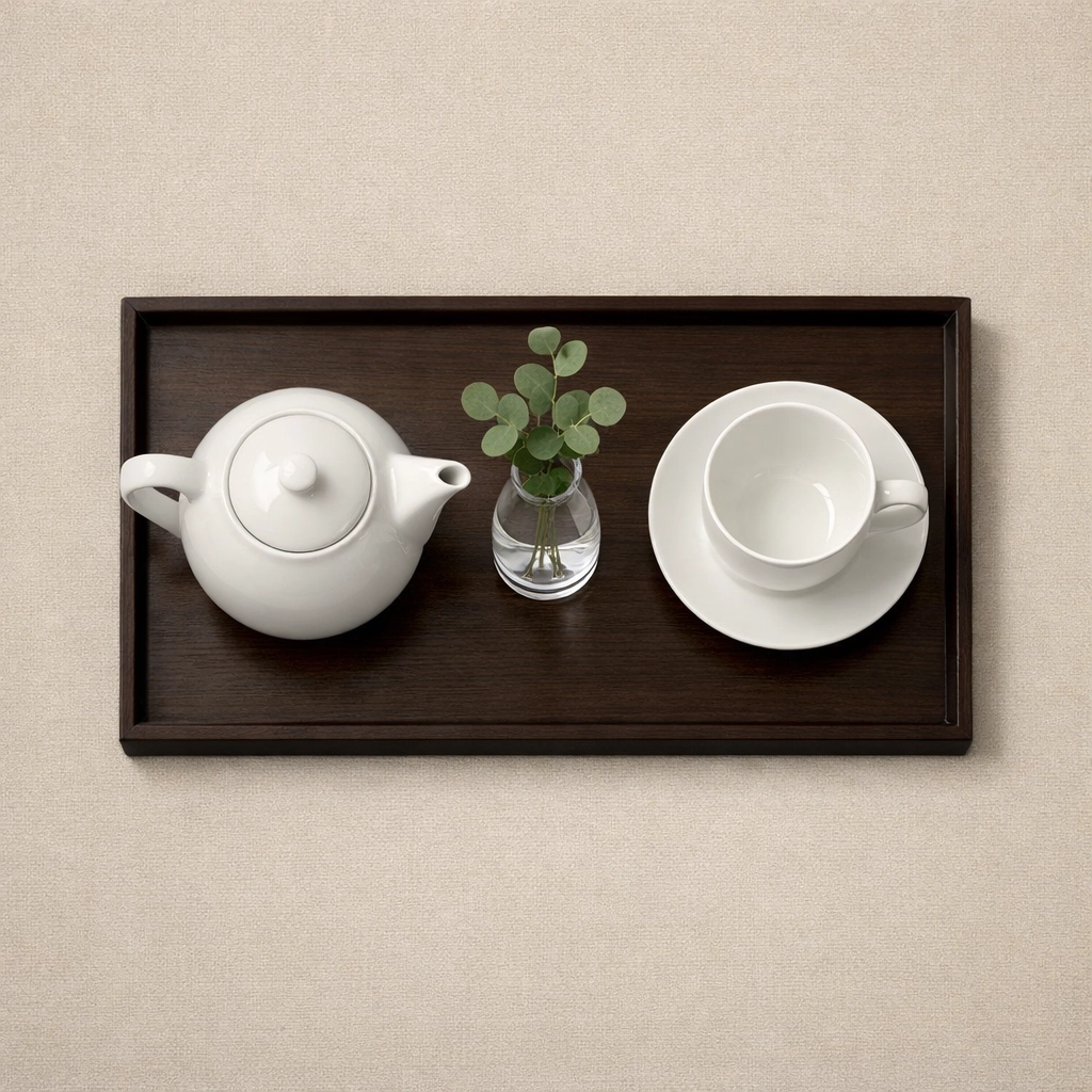 Minimalist hotel welcome tray with teapot and cup showing proactive hospitality service excellence.