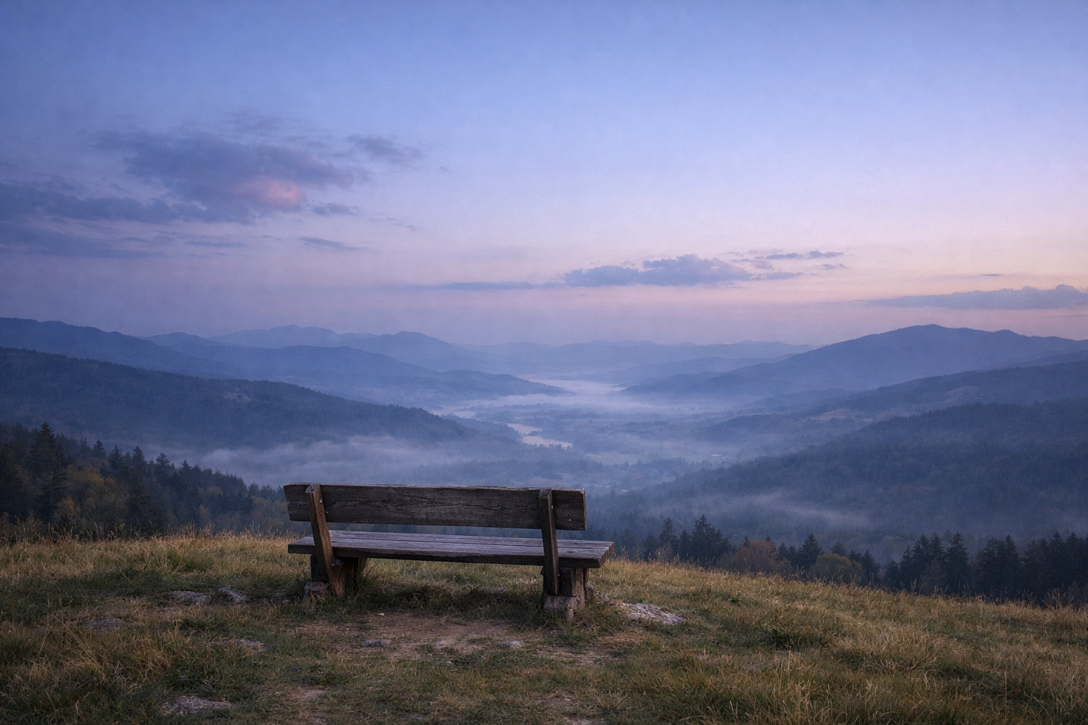 Tranquil hilltop bench overlooking a misty valley, offering a peaceful space for pet loss reflection.