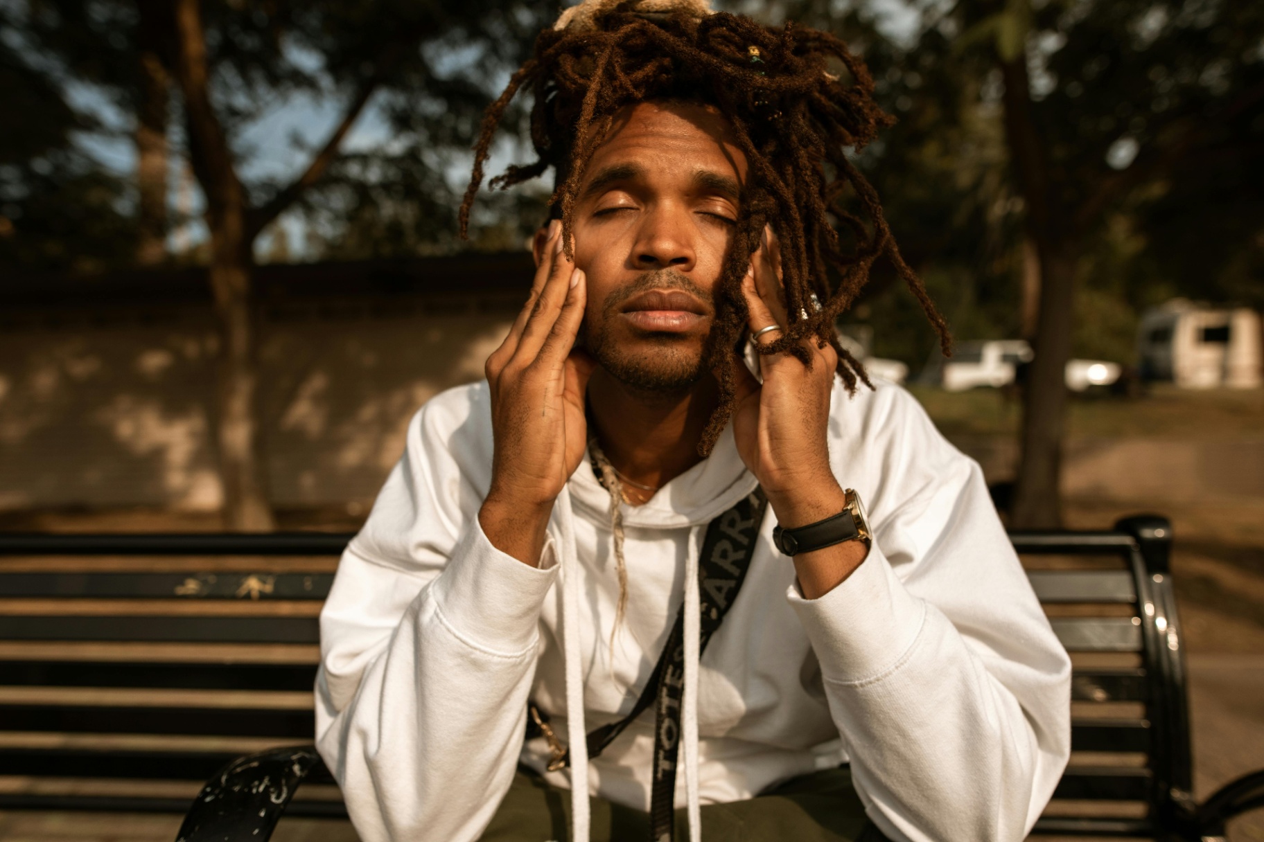 Young Man Meditating on Park Bench