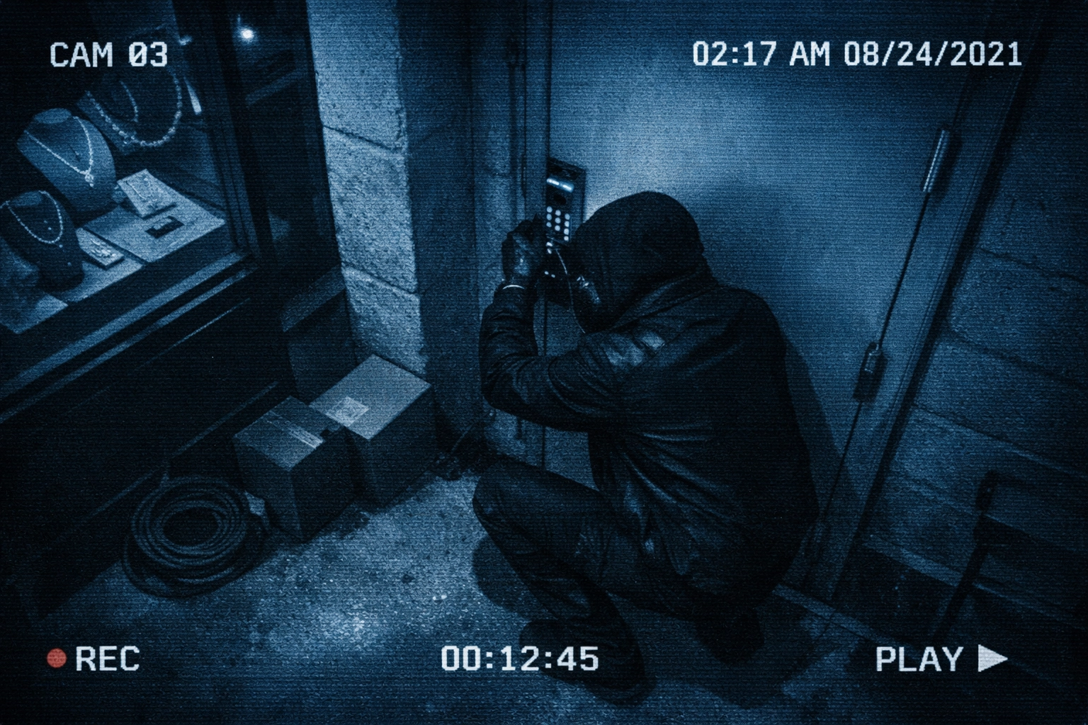 Security camera footage of suspicious figure at luxury jewelry store rear entrance at night