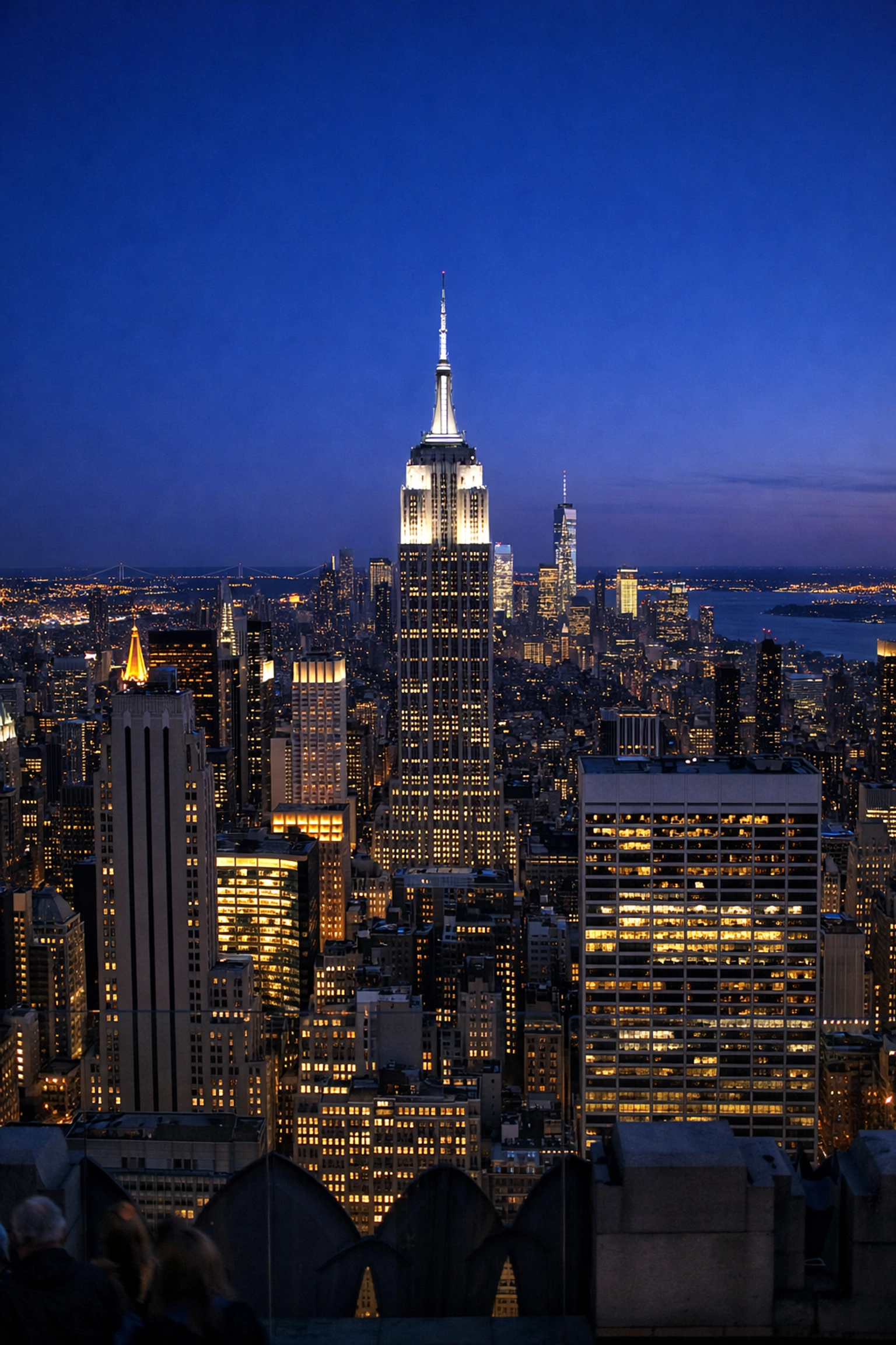 Manhattan skyline at twilight featuring the Empire State Building from Top of the Rock observation deck.
